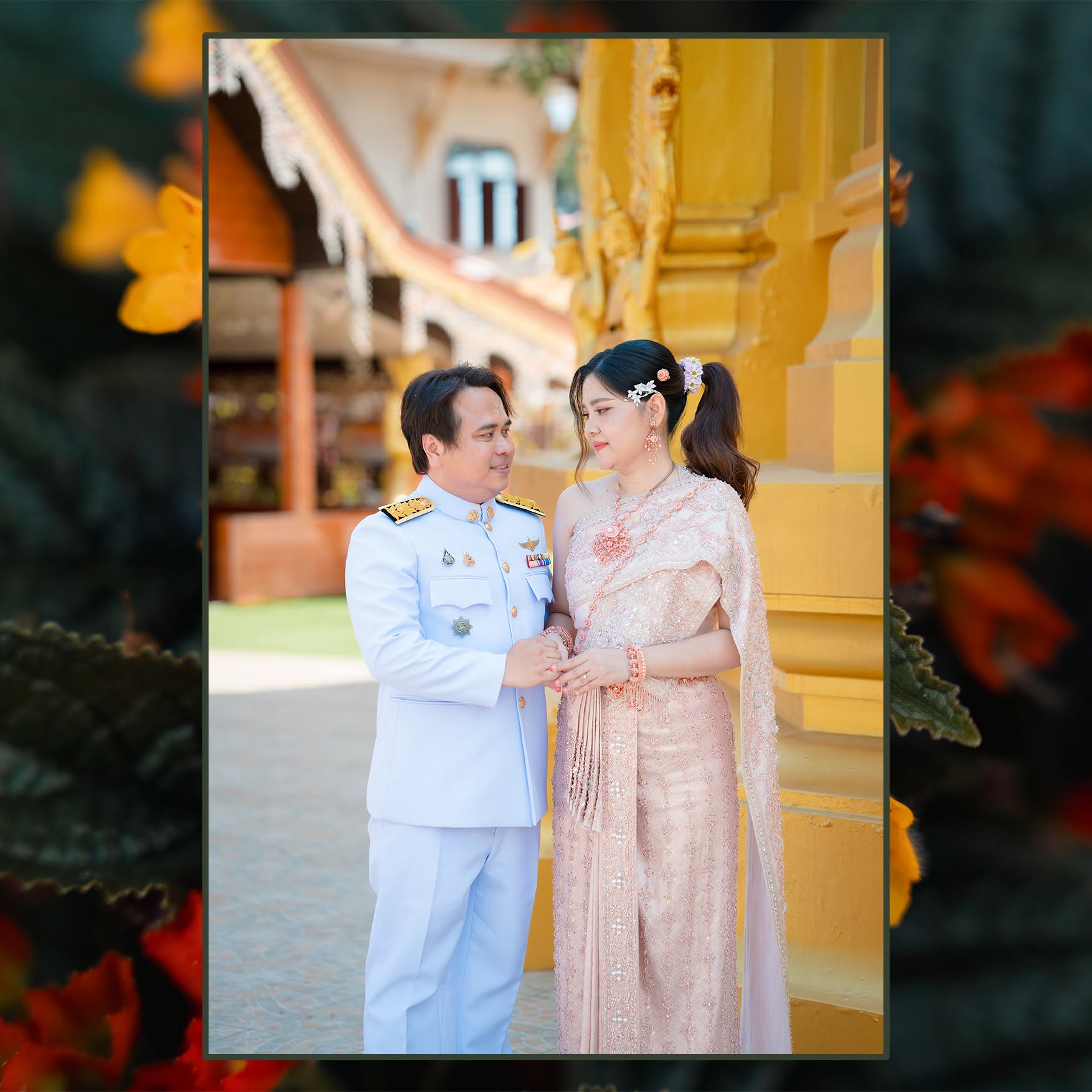 คู่บ่าวสาวในชุดพิธีไทยถ่ายภาพหน้าอาคารสีทอง